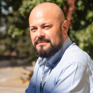 bald latino man with beard wearing collared shirt